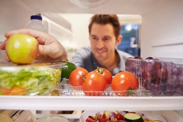 冷蔵庫を見る男性