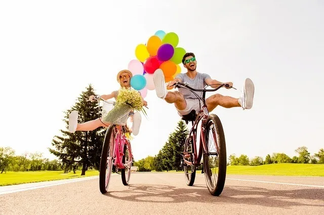 風船と自転車で楽しそうに遊ぶ男女